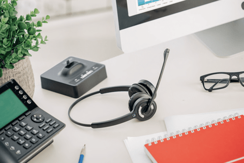 The difference between wireless and bluetooth; wireless headset on a desk with base